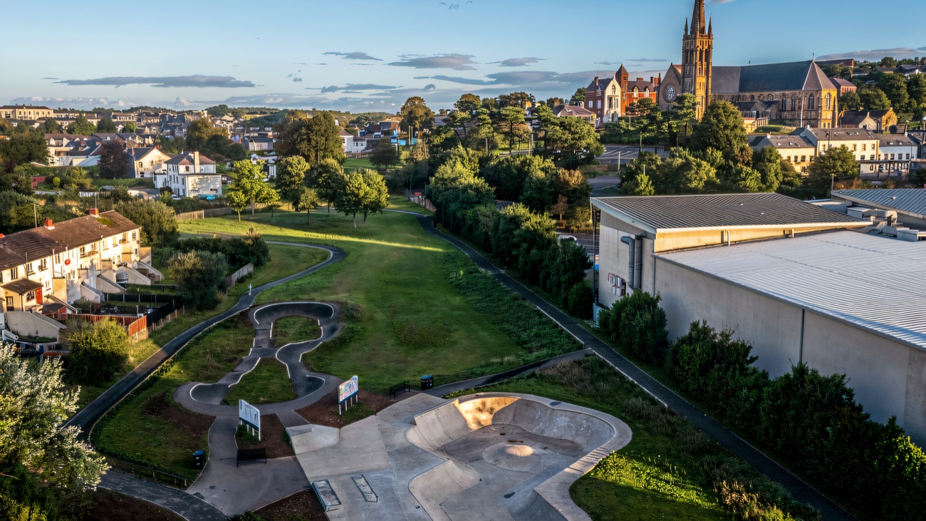 The concrete bowl and winding pump track from the air, with Downpatrick behind