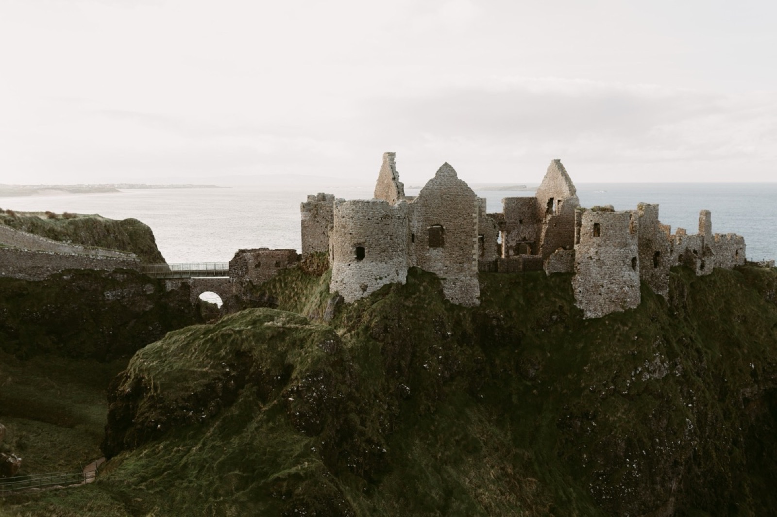 The full ruin in warm light with the bridge across to the rock