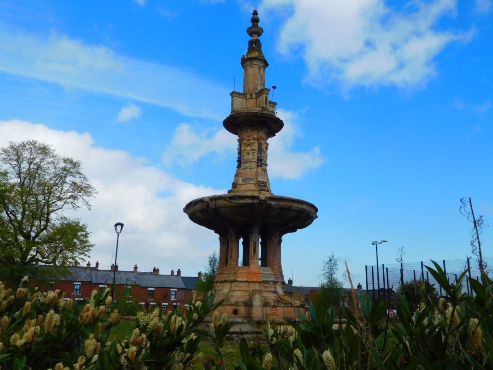 The tall three-tier Victorian terracotta fountain at Dunville Park against a blue sky