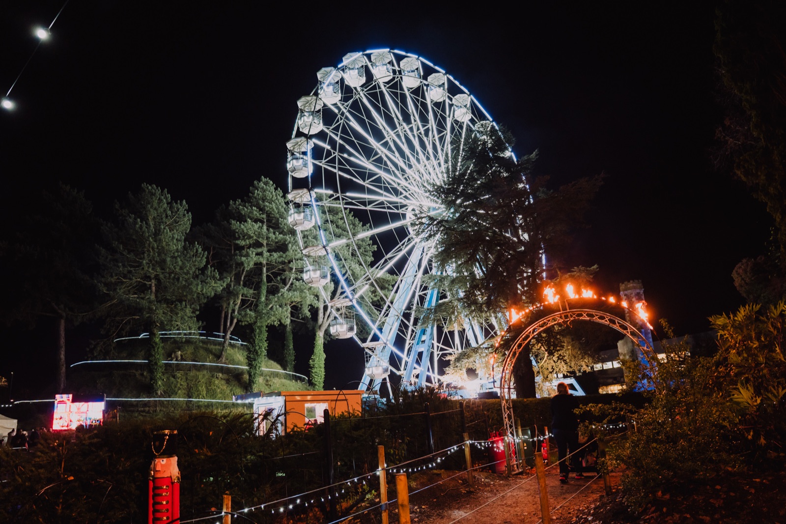 The illuminated big wheel and a lit archway on the trail at the Enchanted Winter Garden, Antrim Castle Gardens, at night