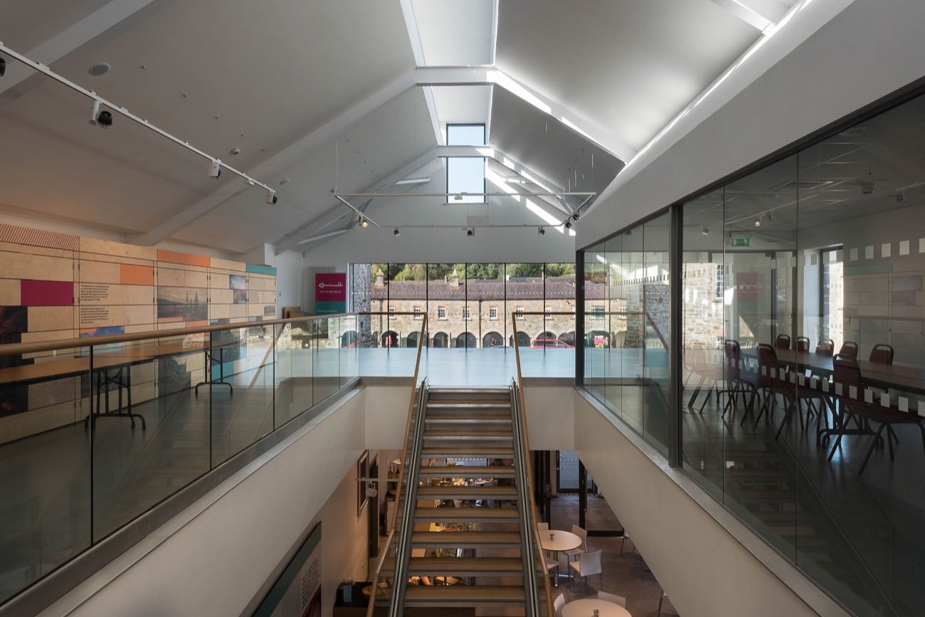 Inside the museum at Enniskillen Castle — a bright modern gallery with a glass balustrade and a view out over the castle courtyard