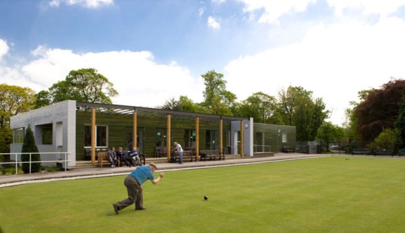 A bowling green and modern pavilion at Falls Park on a bright day