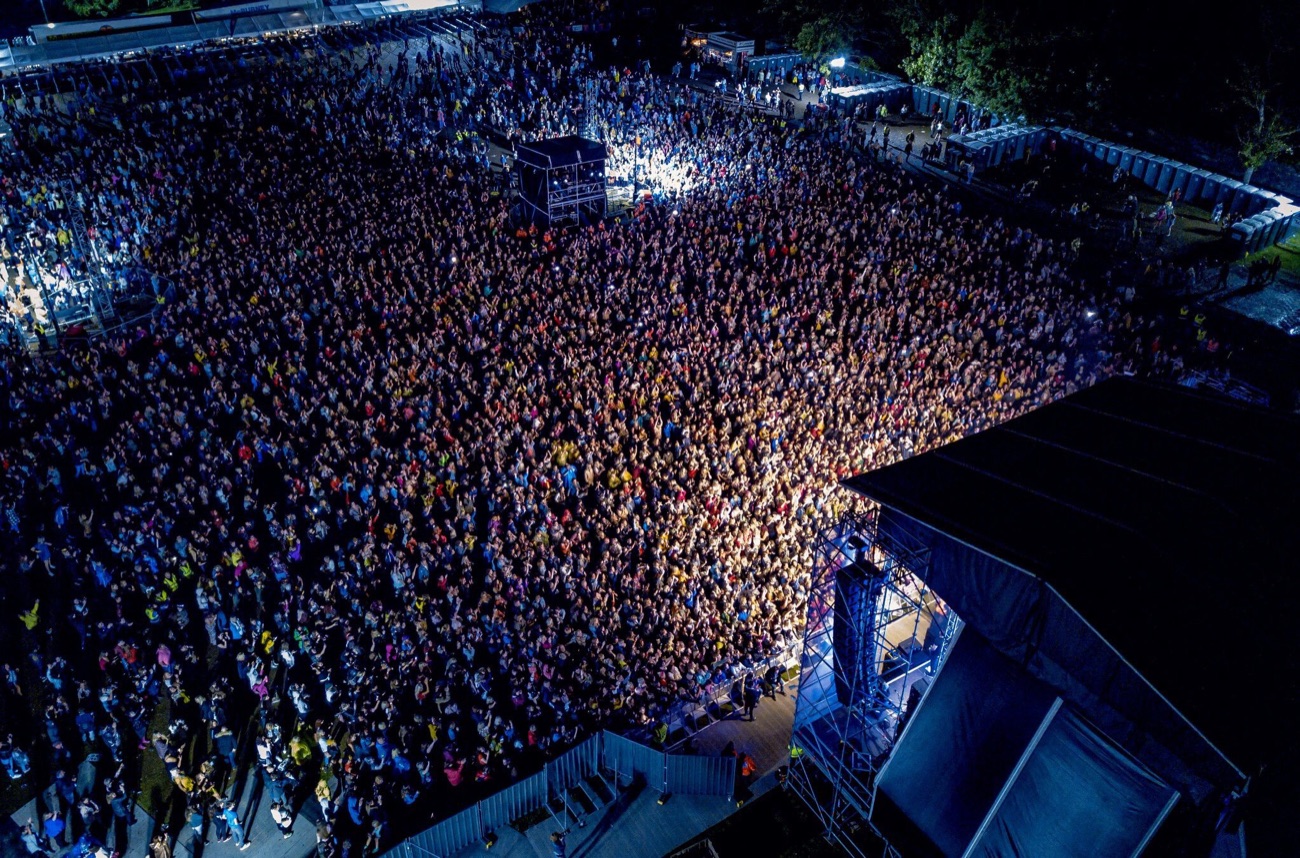 An aerial view of a huge crowd at a Féile an Phobail concert in Falls Park at night