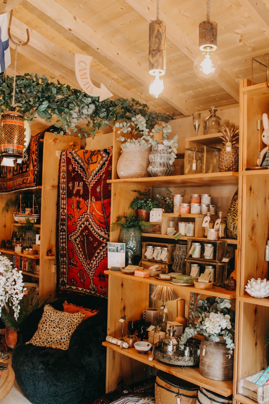 The farm shop corner at Fodder — a rug, timber shelving, ceramics and dried flowers