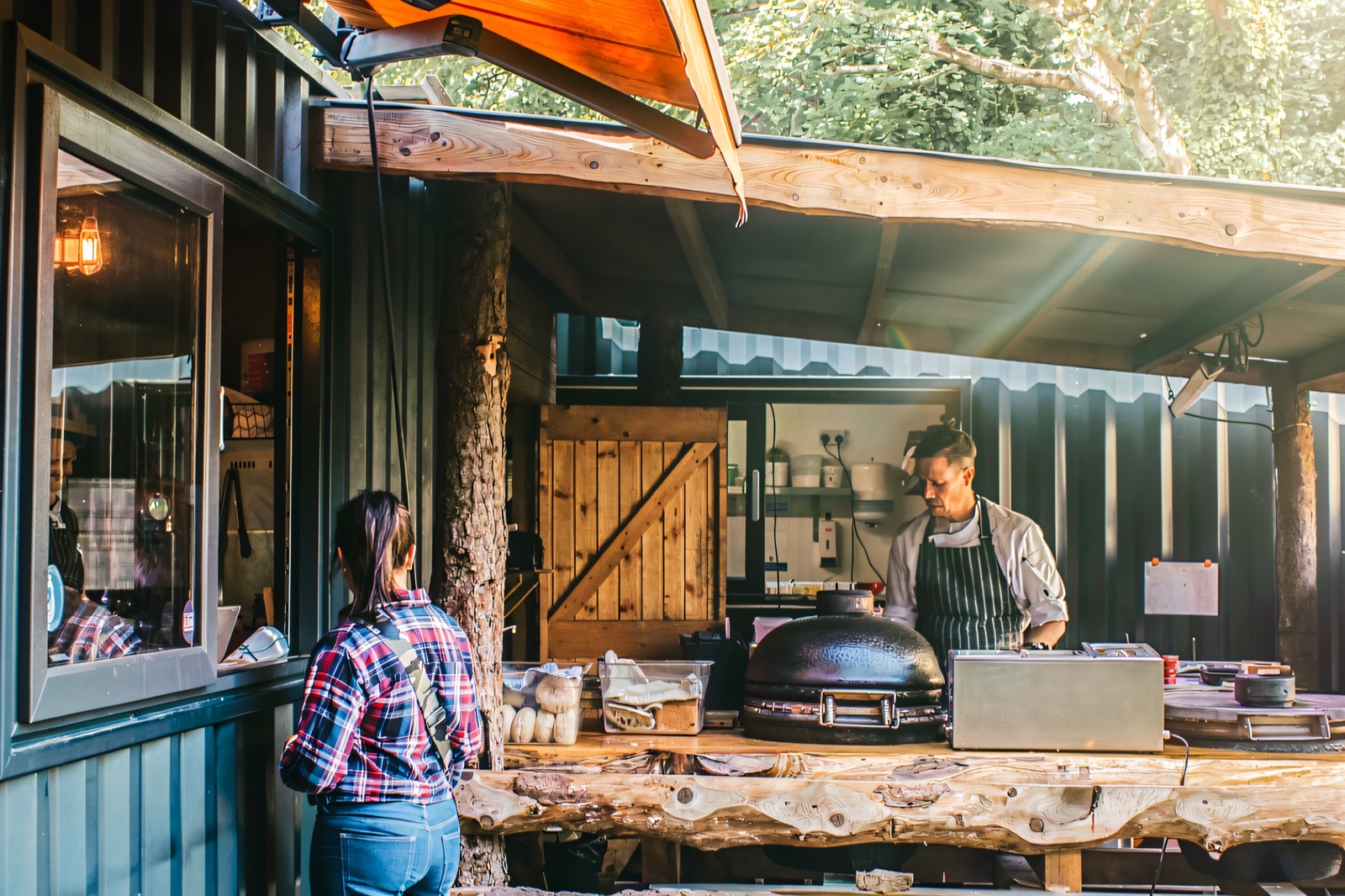 Inside a tipi at Fodder: a log burning in an open fire pit in the floor, fairy lights and wooden benches