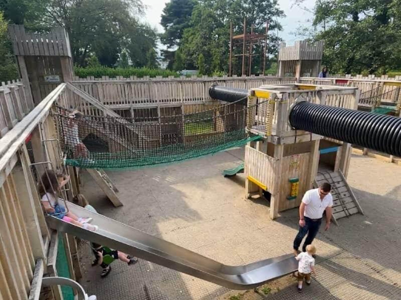 The outdoor wooden adventure fort with net bridges, black tube tunnels and climbing walls