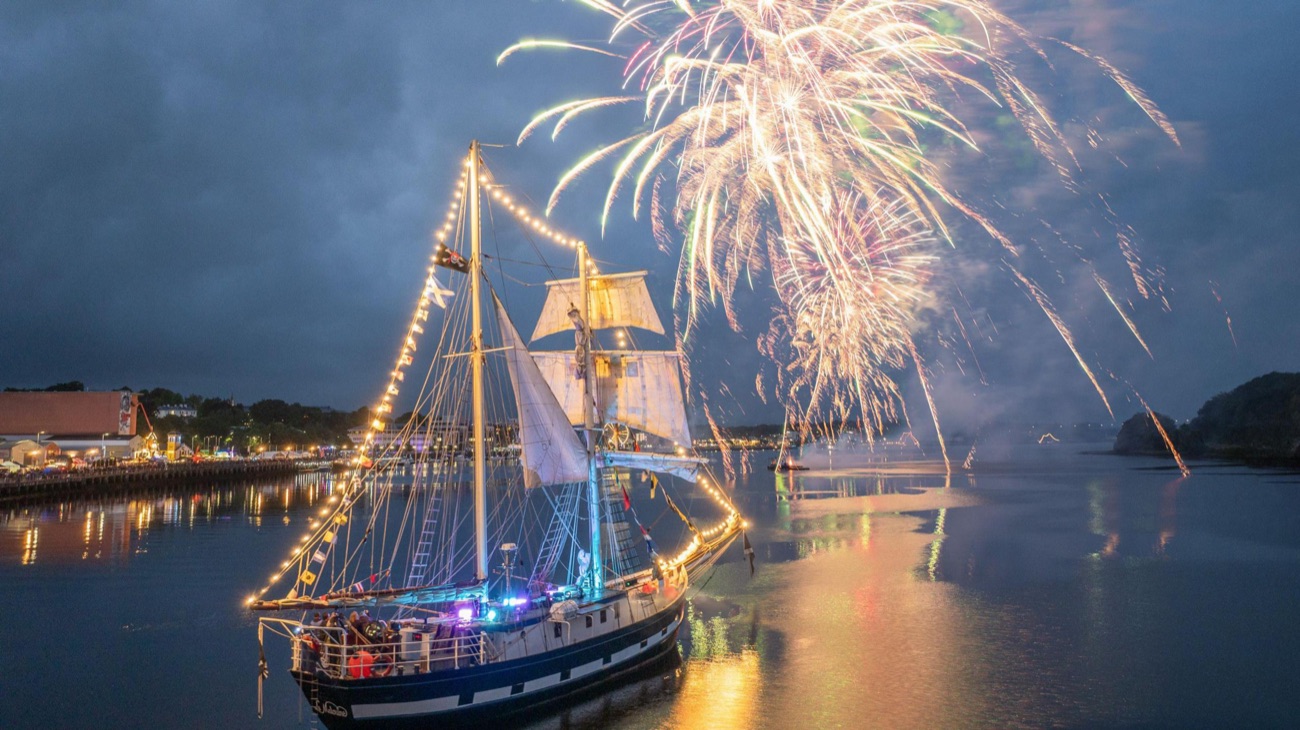 Fireworks bursting over an illuminated tall ship on the River Foyle at night at the Foyle Maritime Festival