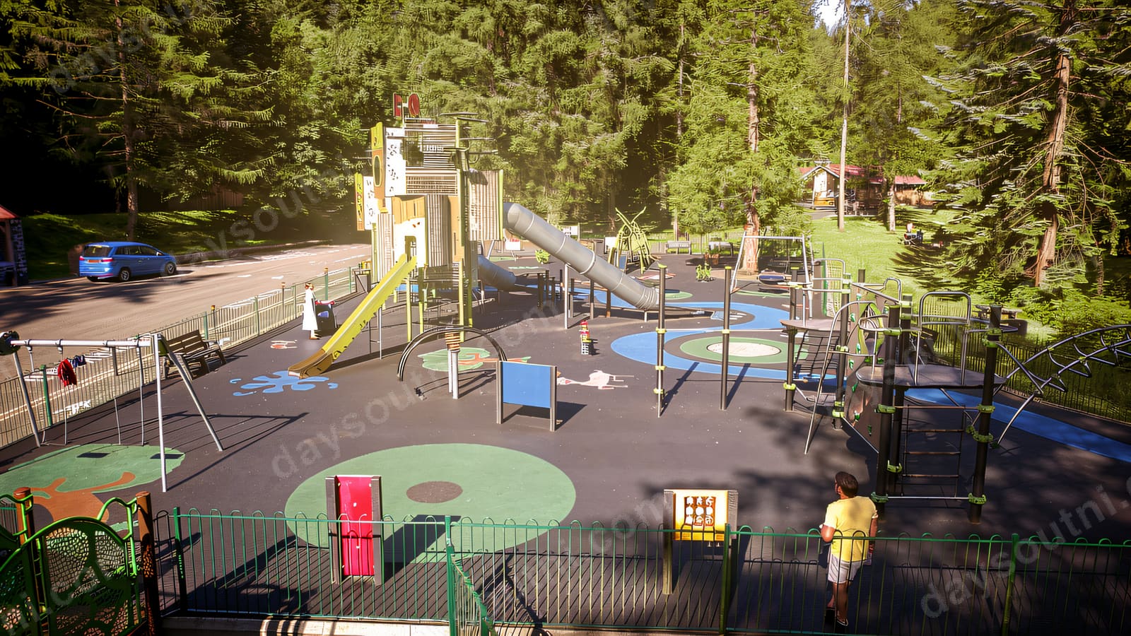 A wide view over the whole play area — slides, swings, roundabout and climbing frames ringed by forest.