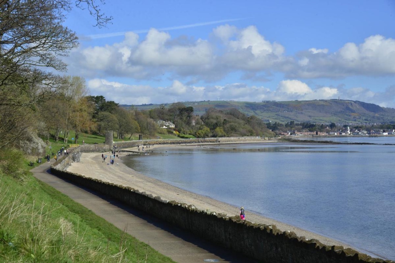 The shore path at Hazelbank Park curving along Belfast Lough with Cave Hill in the distance
