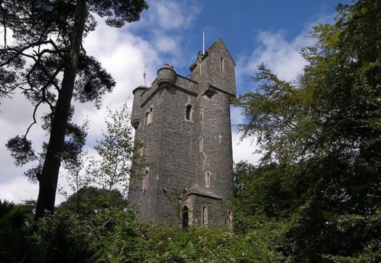 Helen's Tower seen from below through the estate trees against a blue sky