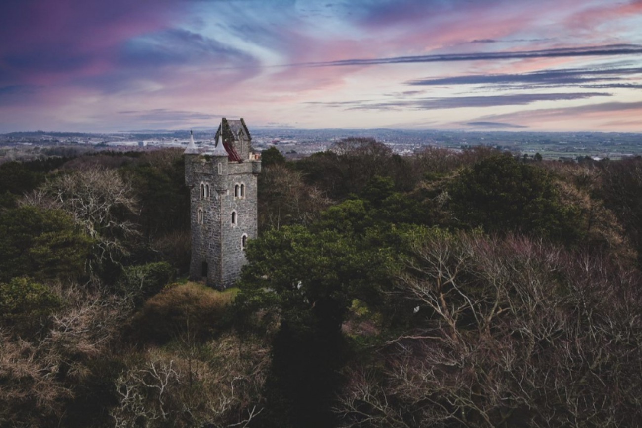 Aerial view of Helen's Tower on its wooded hilltop above Belfast Lough at dusk
