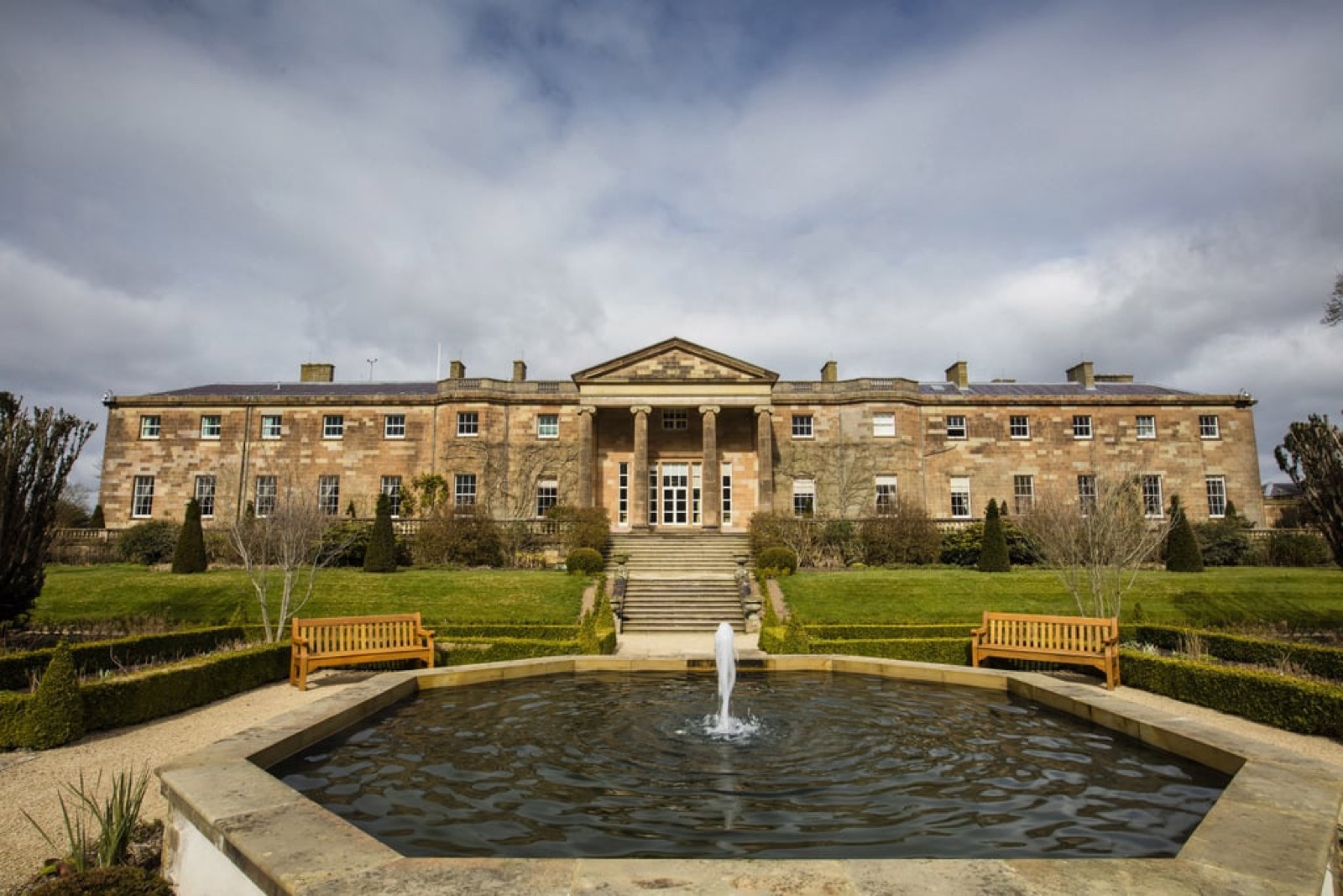 The Georgian front of Hillsborough Castle with the royal standard flying over a striped lawn