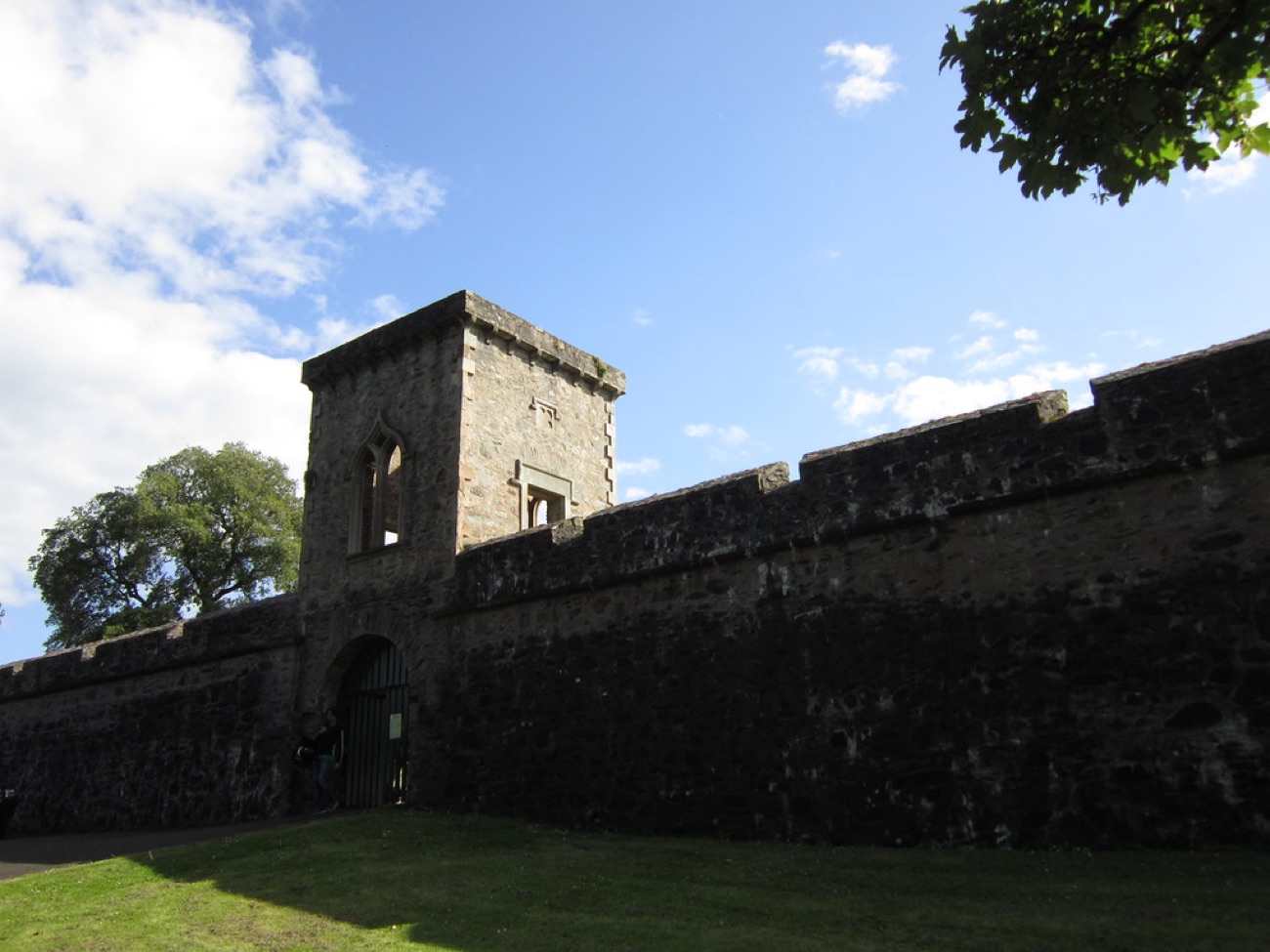 The stone curtain wall and gatehouse tower of Hillsborough Fort rising against a blue sky