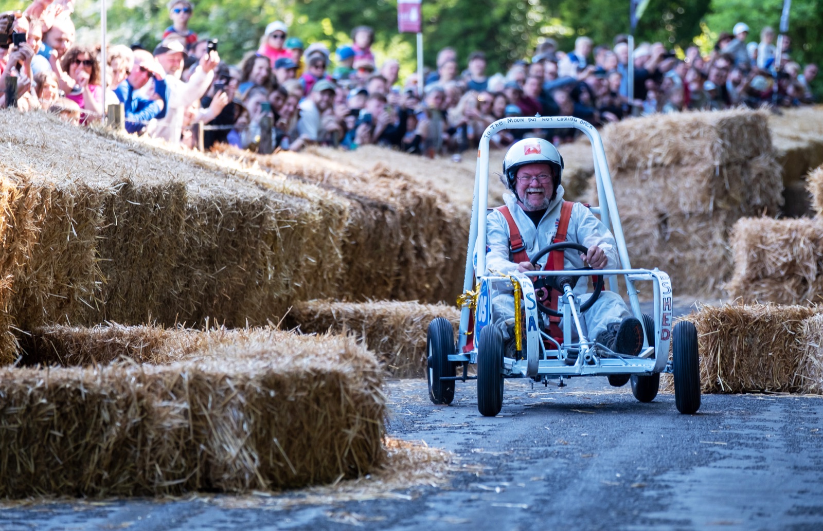 A home-made soapbox cart racing down the hill between straw bales as crowds cheer at the Hillsborough Oyster Festival