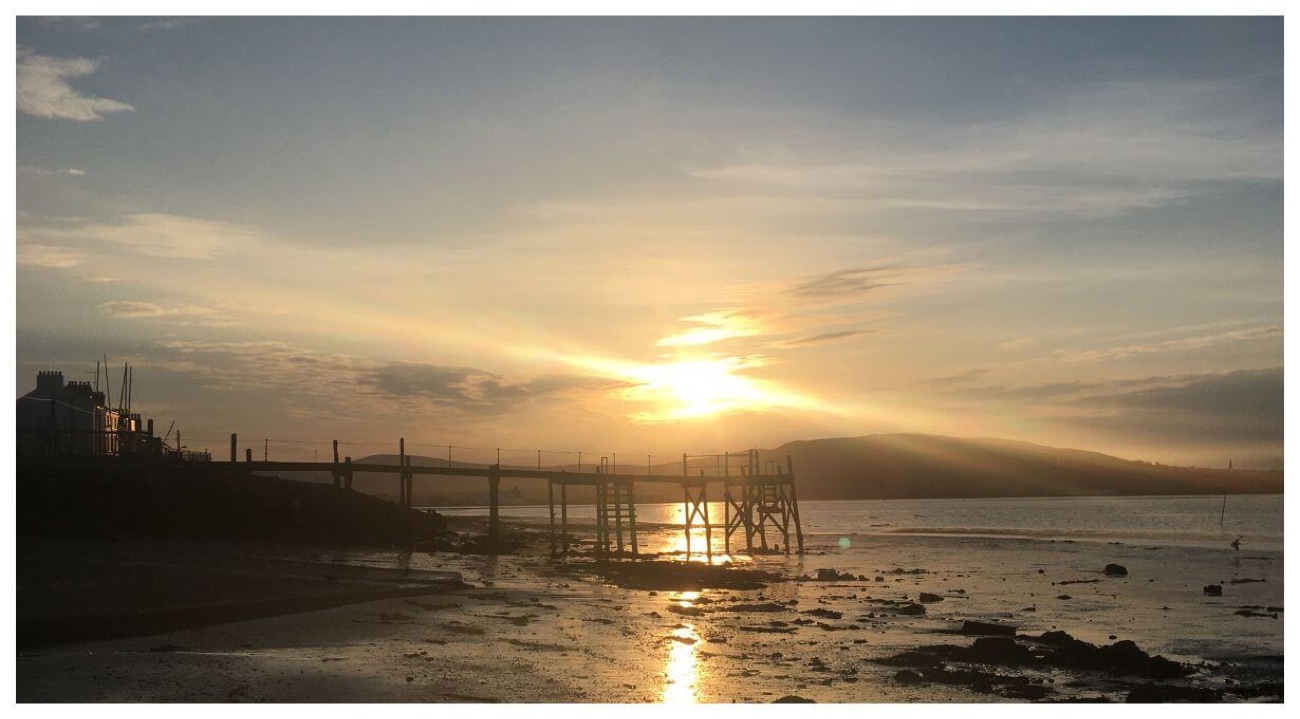 Sunset over Belfast Lough from the Holywood shore with a jetty silhouetted
