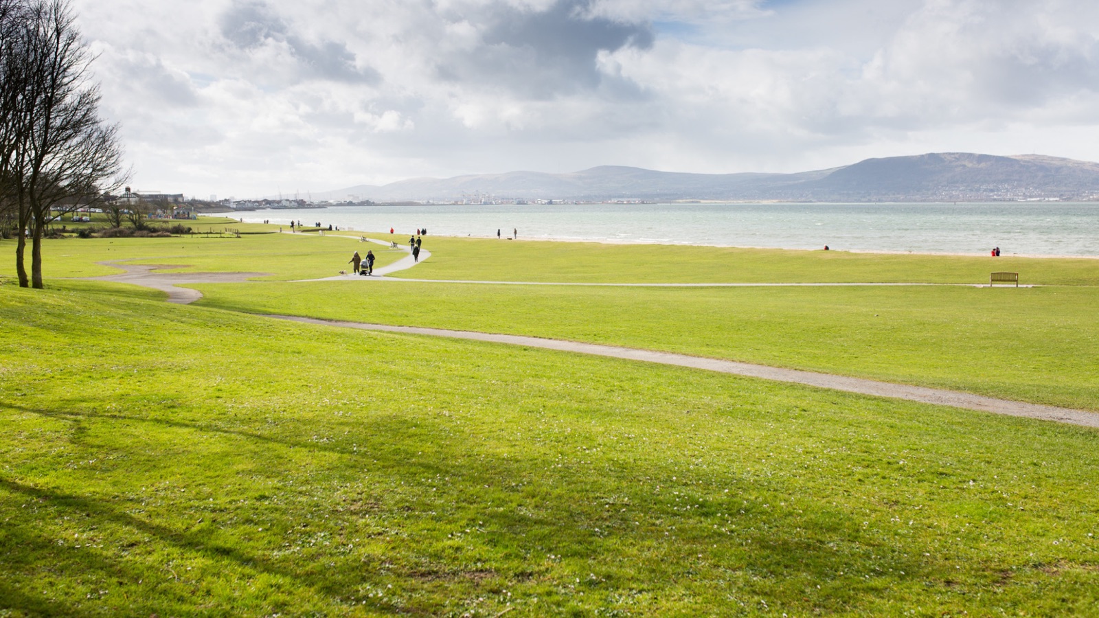 The wide flat green at Holywood seafront sweeping down to Belfast Lough with the Antrim hills beyond