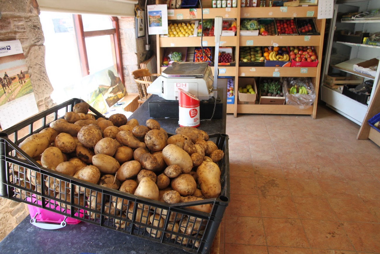 A black crate heaped with Comber potatoes on the shop floor