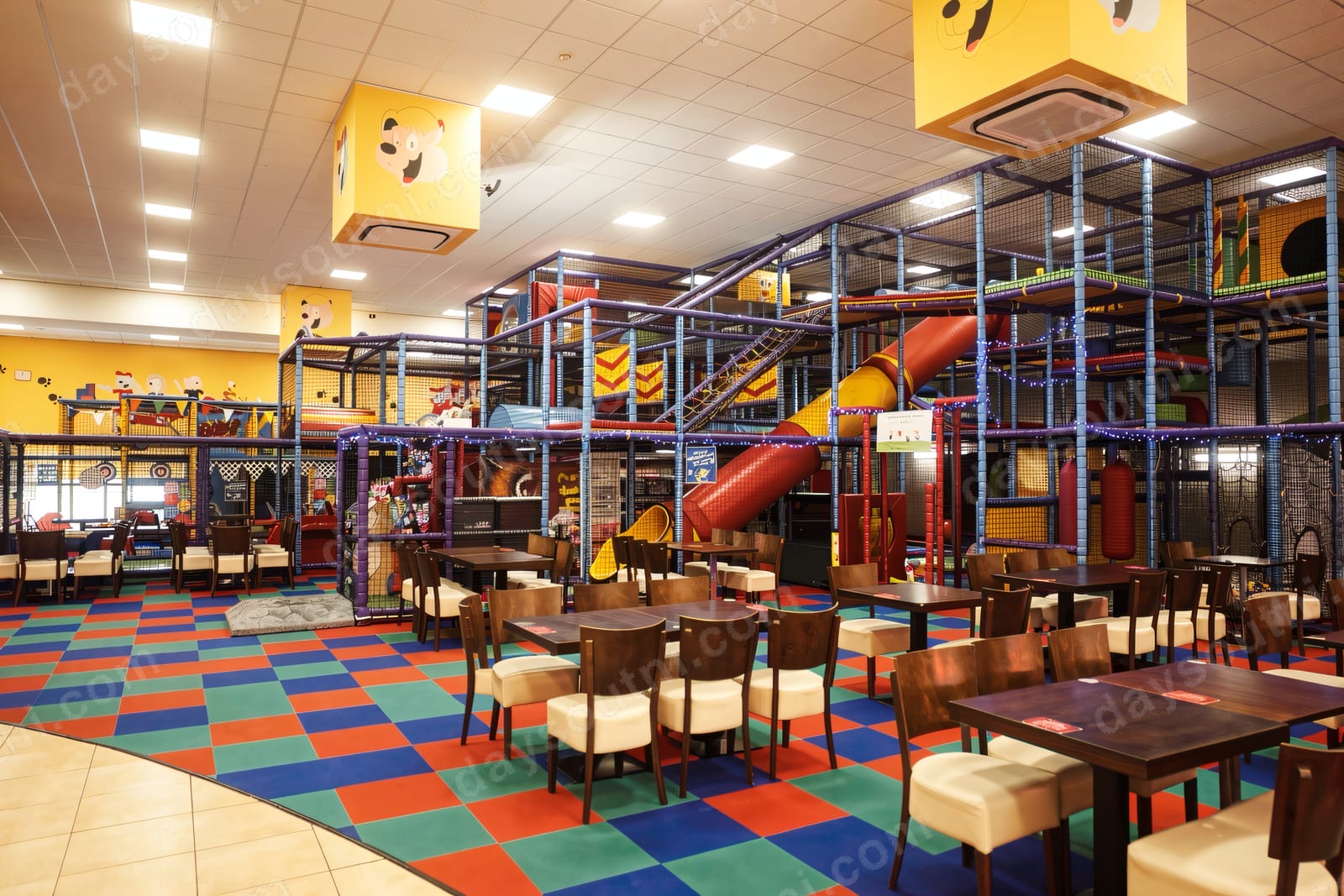 The big multi-level soft play frame at Alley Cats in the Jet Centre, Coleraine, with a red slide, netting and café tables in front