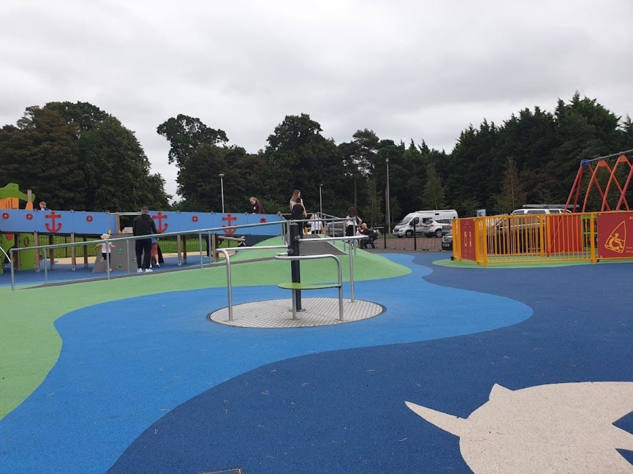 The play park at Jordanstown Loughshore with nautical-themed equipment and blue and green safety surfacing