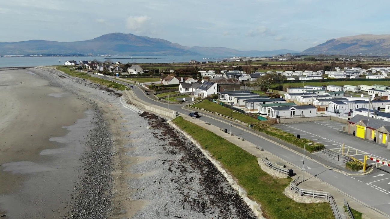 Aerial view of Cranfield beach and the seafront caravans at Kilkeel, with Carlingford Lough and the Mourne Mountains behind