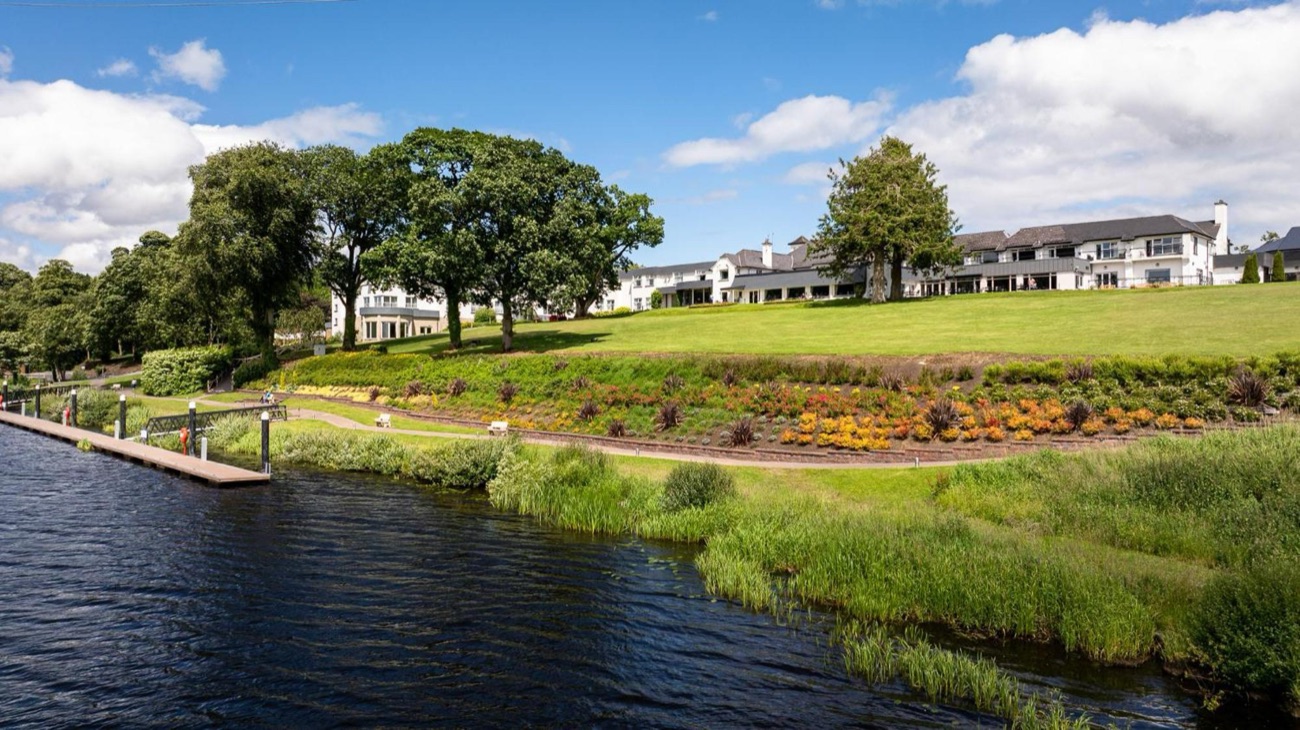 The hotel's lakeside gardens with bright flowerbeds running along the shore of Lough Erne