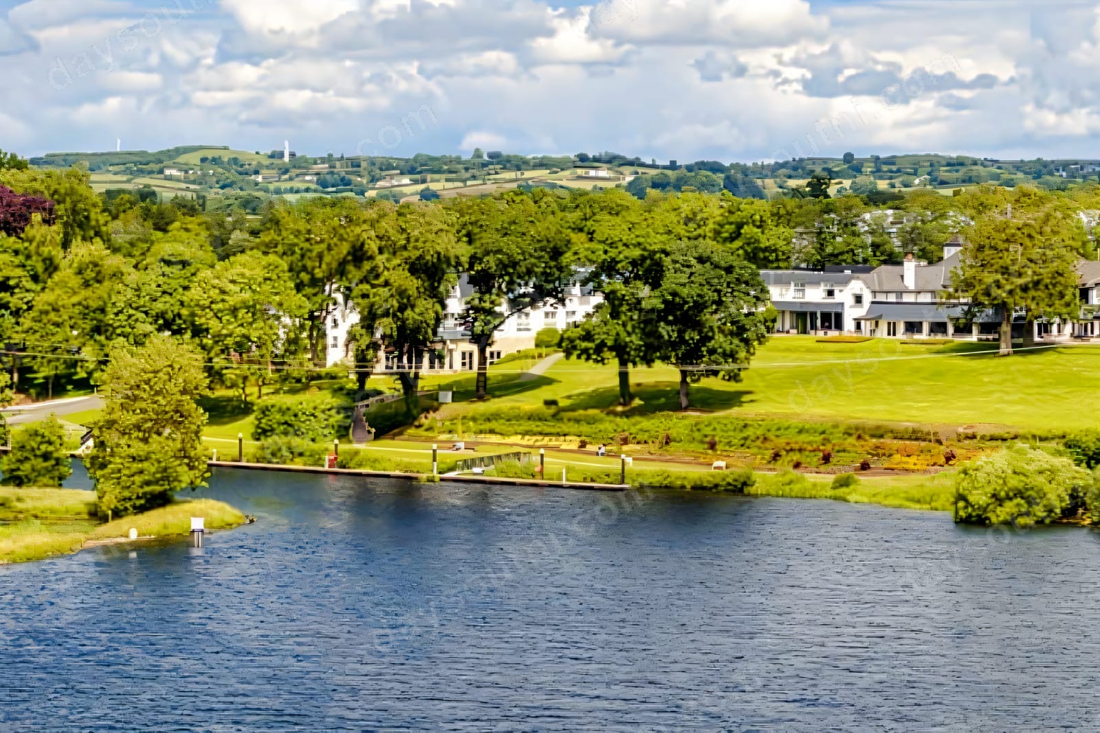 An aerial view of Killyhevlin Lakeside Hotel spread along the green shore of Lough Erne, with gardens, a jetty and the water in front