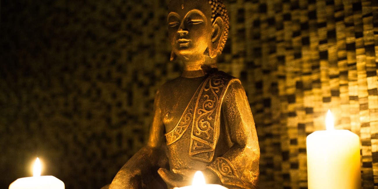 A gilded Buddha and candlelight set the calm tone at the spa.