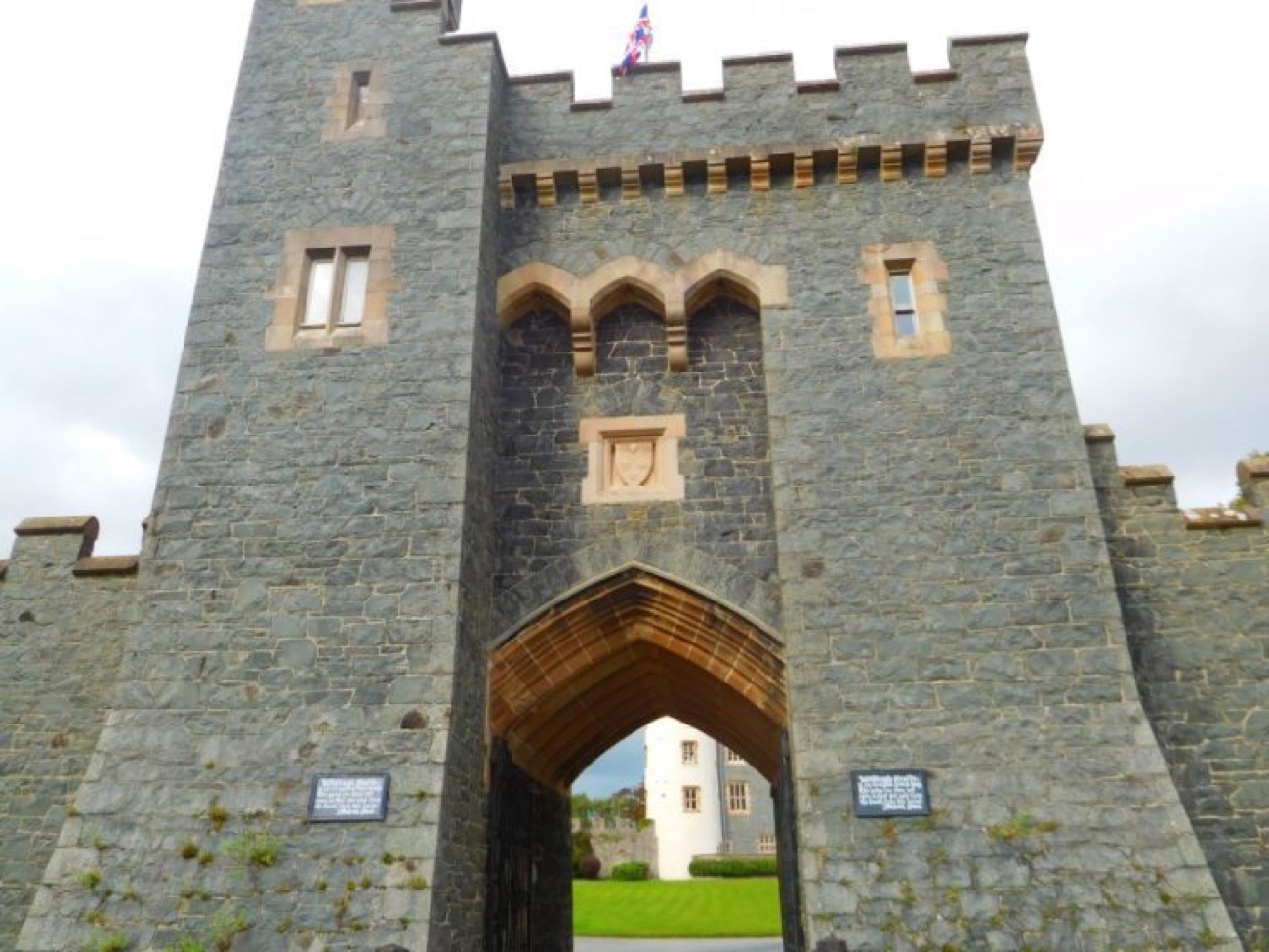The crenellated stone gatehouse arch of Killyleagh Castle, the house glimpsed through the gate
