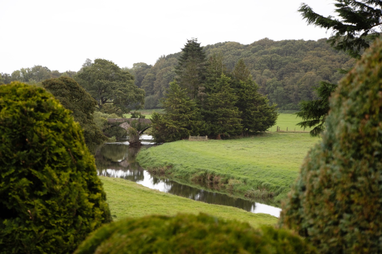 The river winding through the parkland of the Killymoon demesne with woodland on the hill behind