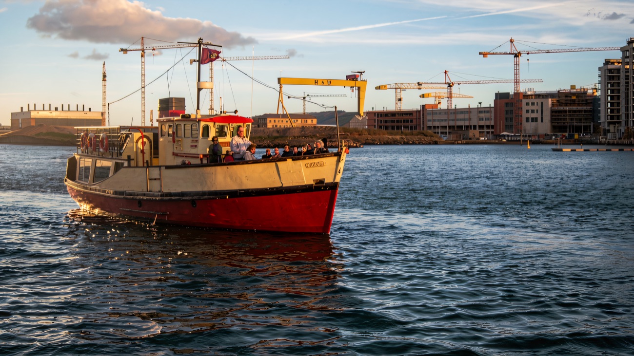 The boat under way with the great yellow Harland & Wolff cranes behind
