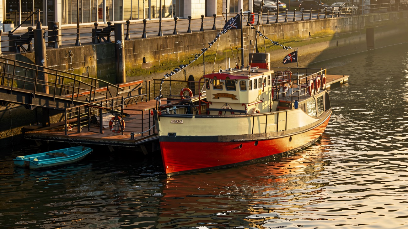 The tour boat Mona moored at the riverside pontoon