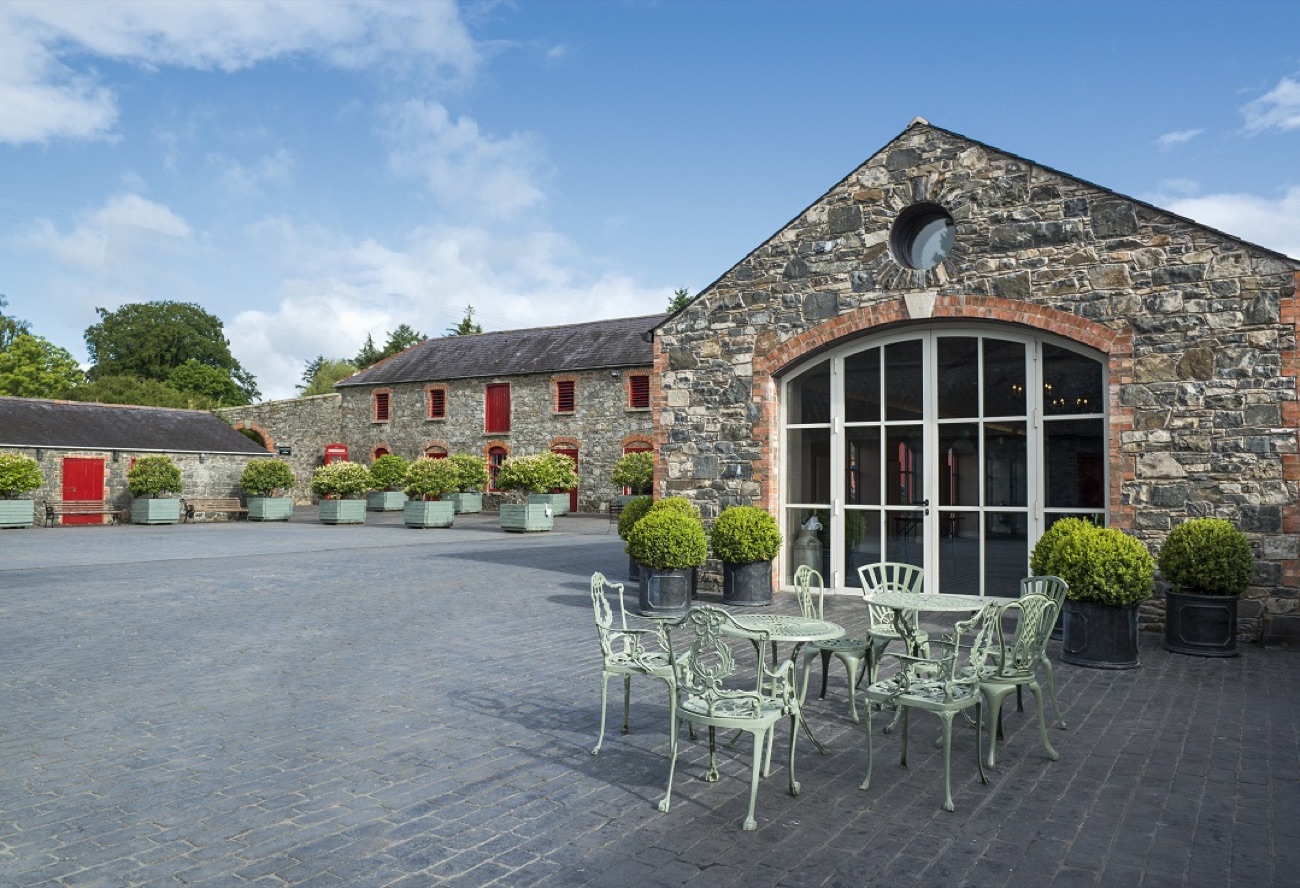 The cobbled courtyard and stone barn with its tall arched glass doors