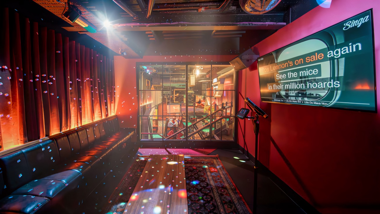 A private karaoke room with booth seating and a big screen