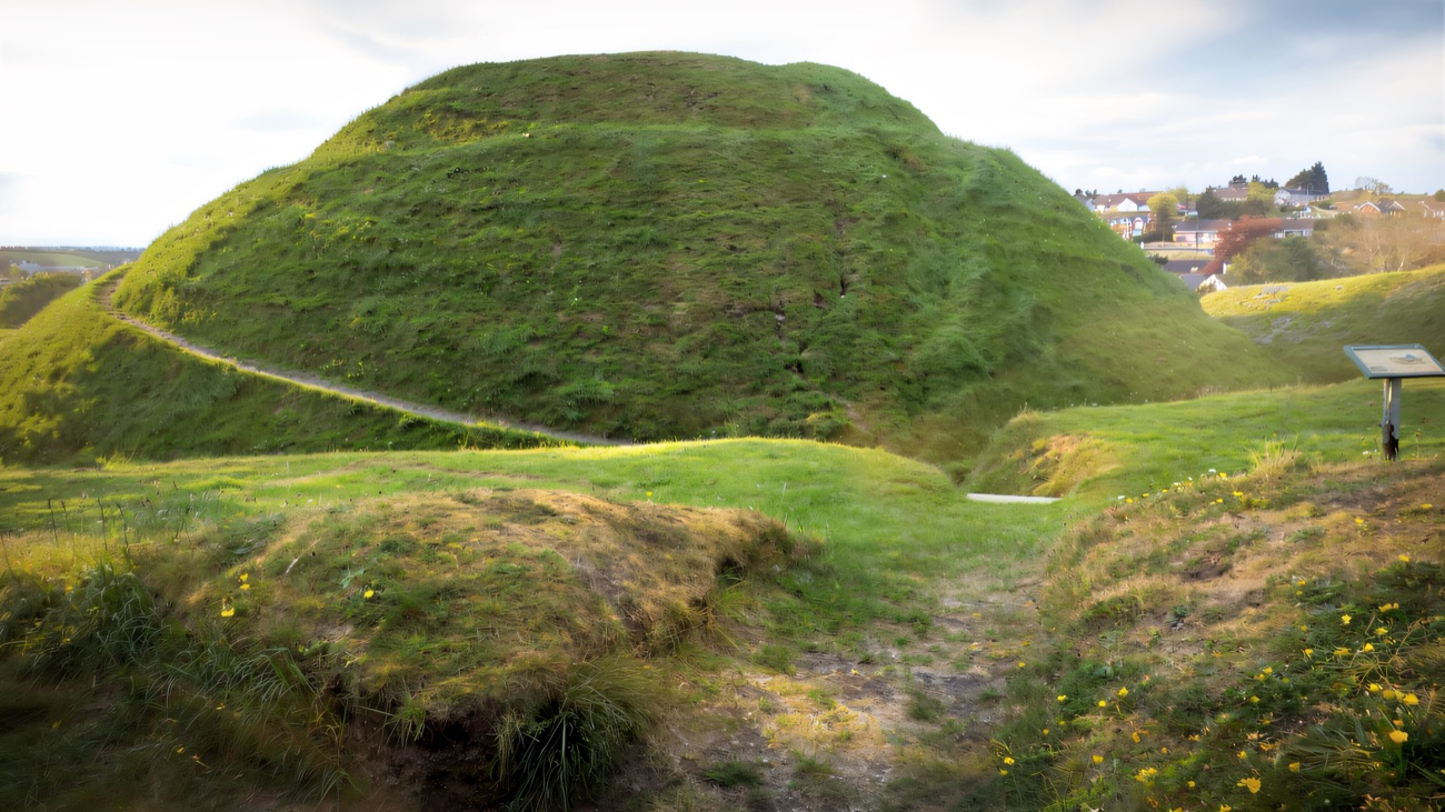 The great grassy Norman motte rising above the town, an earthwork mound raised in the medieval period.