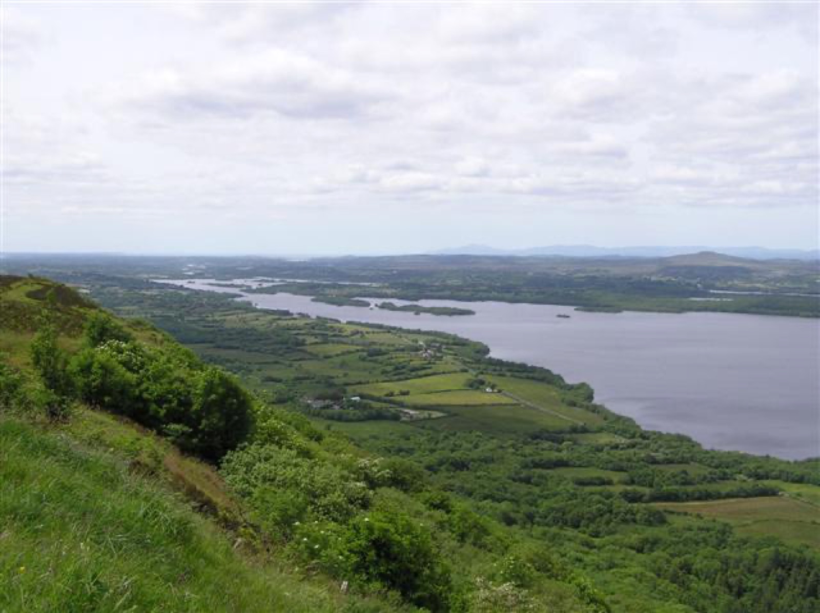 The view from Magho Viewpoint on a bright day — Lower Lough Erne winding away between green fields and low hills.