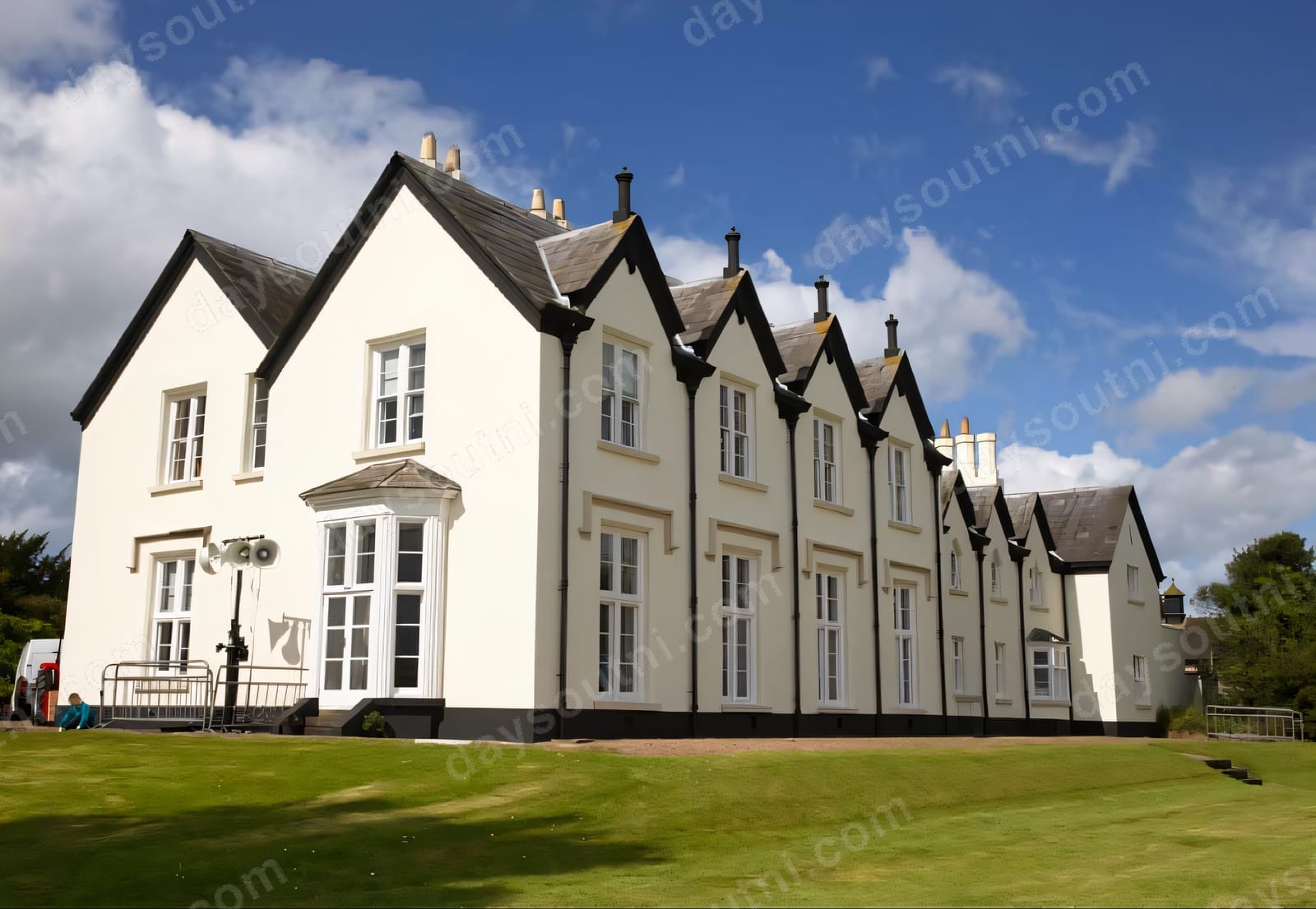 The white-gabled Loughgall Manor on a green rise under a blue sky at Loughgall Country Park