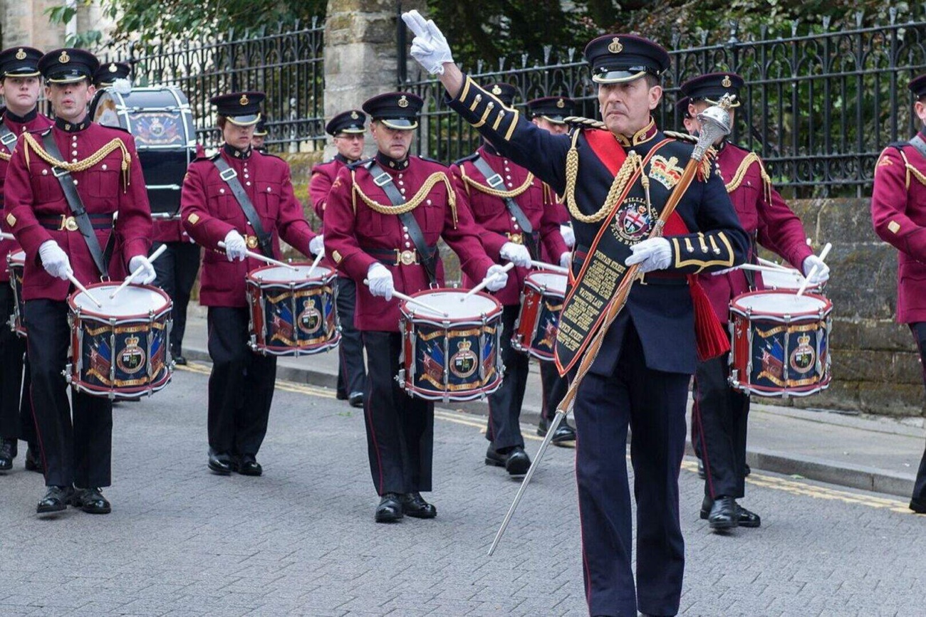 A marching band in ceremonial uniform with drums parading through Derry at the Maiden City Festival