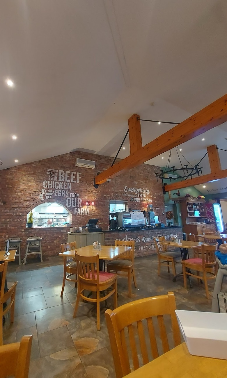 The McKee's restaurant: brick wall lettered 'beef, chicken and eggs from our farm', wooden tables and beams