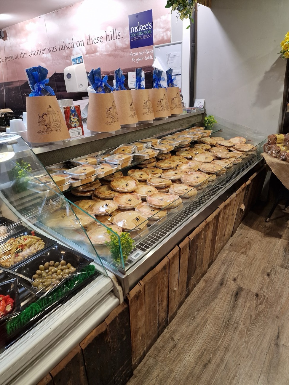 A counter of pies at McKee's under a sign reading 'the meat at this counter was raised on these hills'