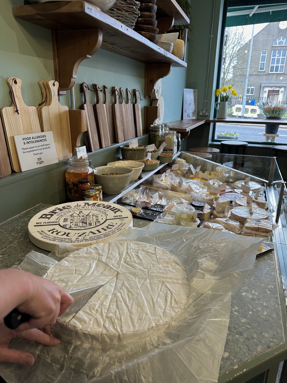 A whole round of cheese being cut at the Millbank counter