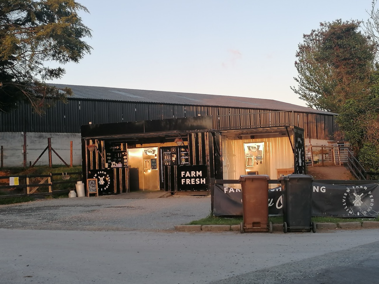The vending shed and the black farm shed behind it at dusk on the Moss Road