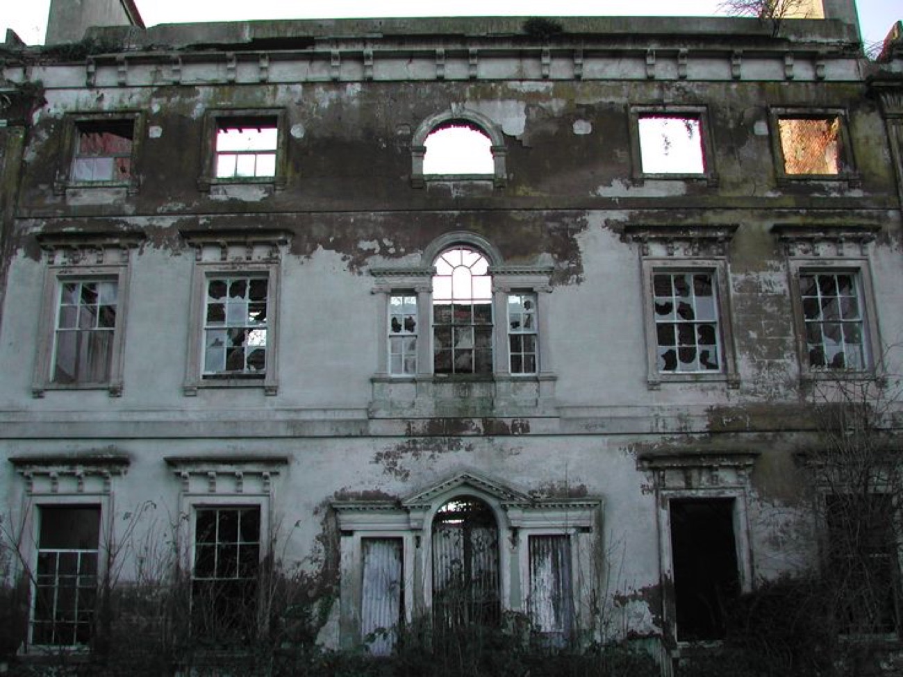 The front of the ruined Mount Panther House, its grand windows empty and the plasterwork peeling