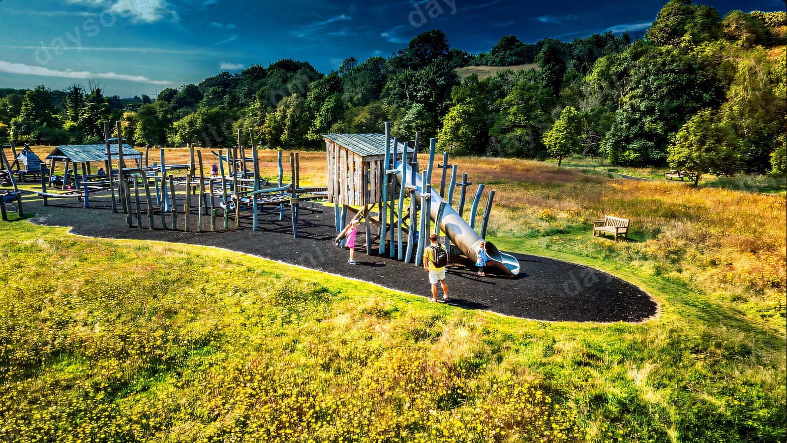 A wide view of the adventure playground with its towers, walkways and slide.