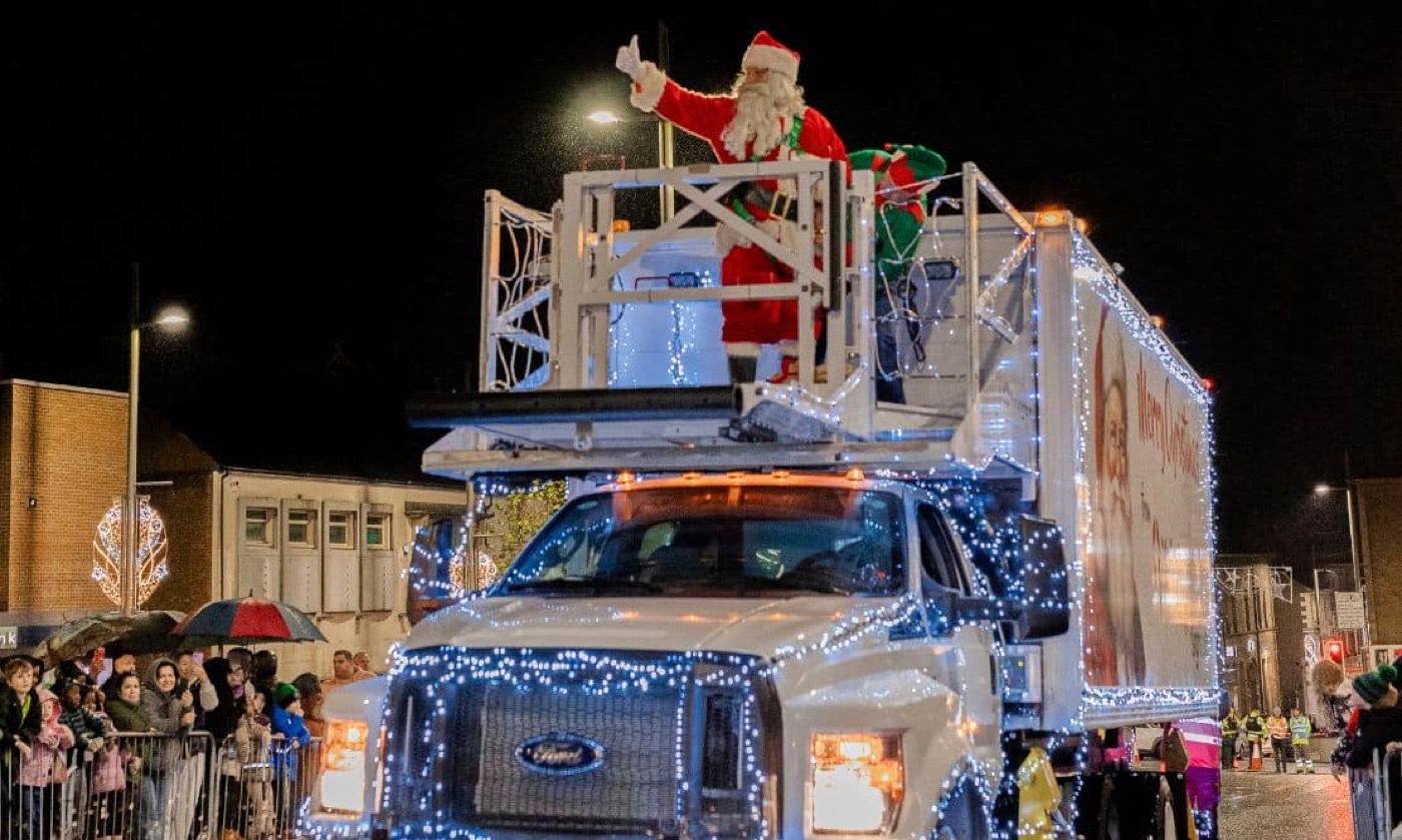 Santa on an illuminated truck passing a crowd at a Mid Ulster Christmas parade