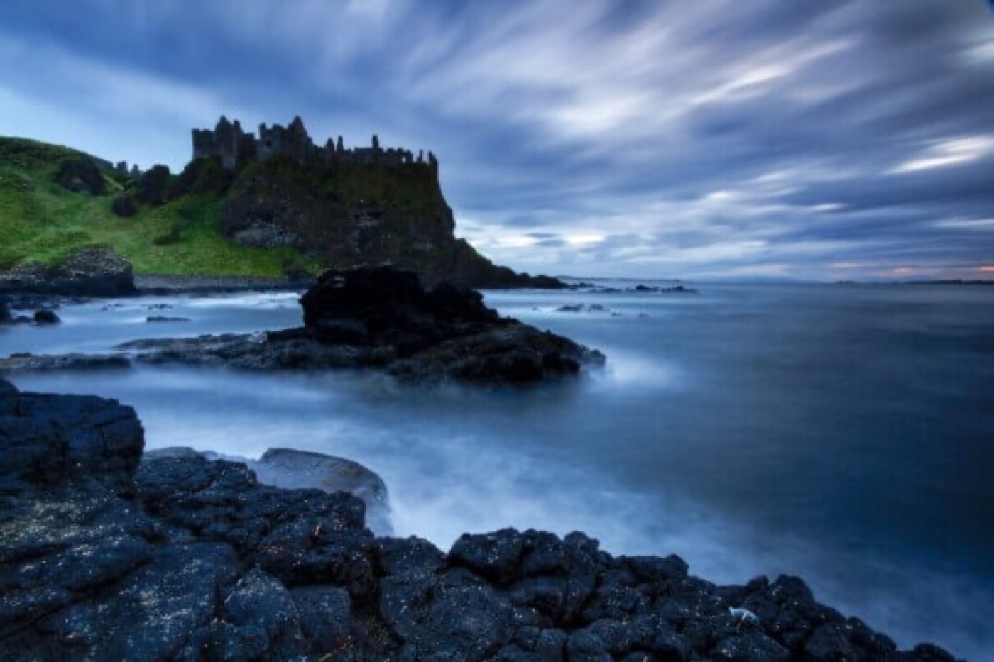 The ruins of Dunluce Castle on the Antrim coast under a stormy sky