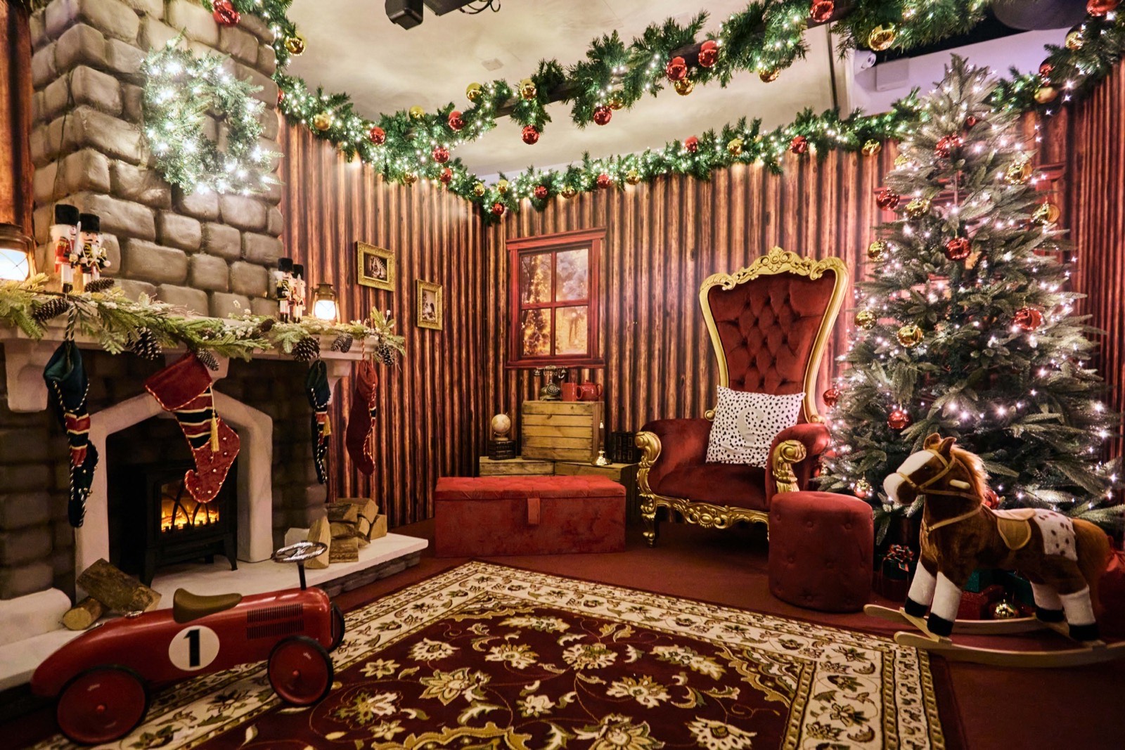 A Santa's grotto set with a fireplace, Christmas tree and red velvet throne