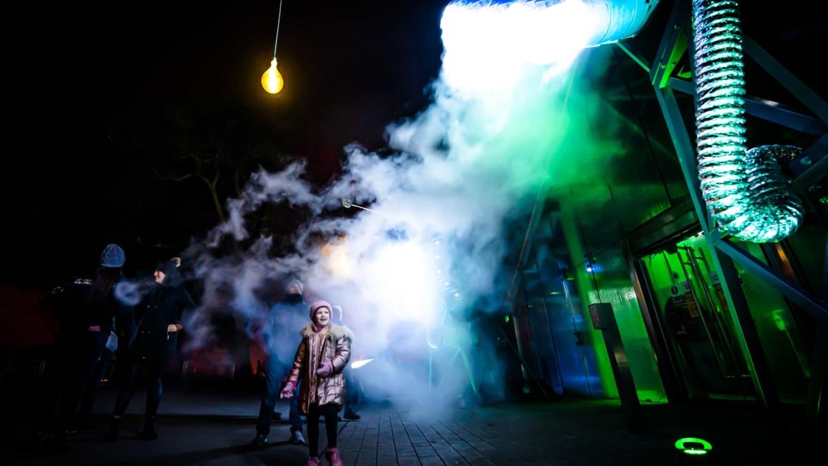 A dramatic night-time science demonstration with steam and glowing coils at the NI Science Festival