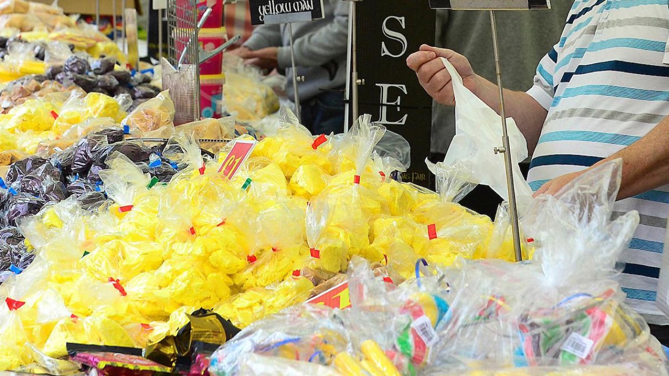 A market stall piled high with bags of bright yellow yellowman honeycomb toffee and dark dulse seaweed
