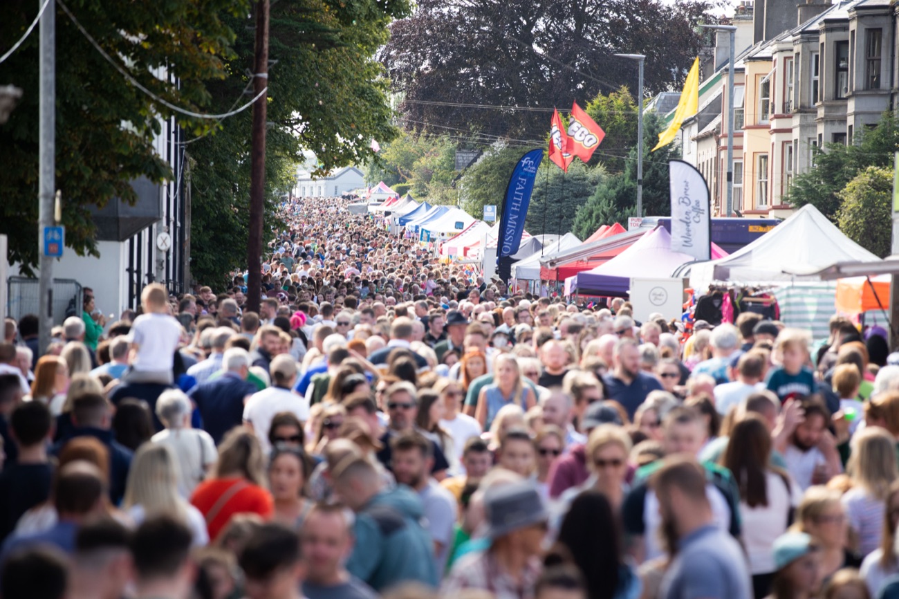 A packed street of market stalls stretching the length of Ballycastle, thronged with fair crowds