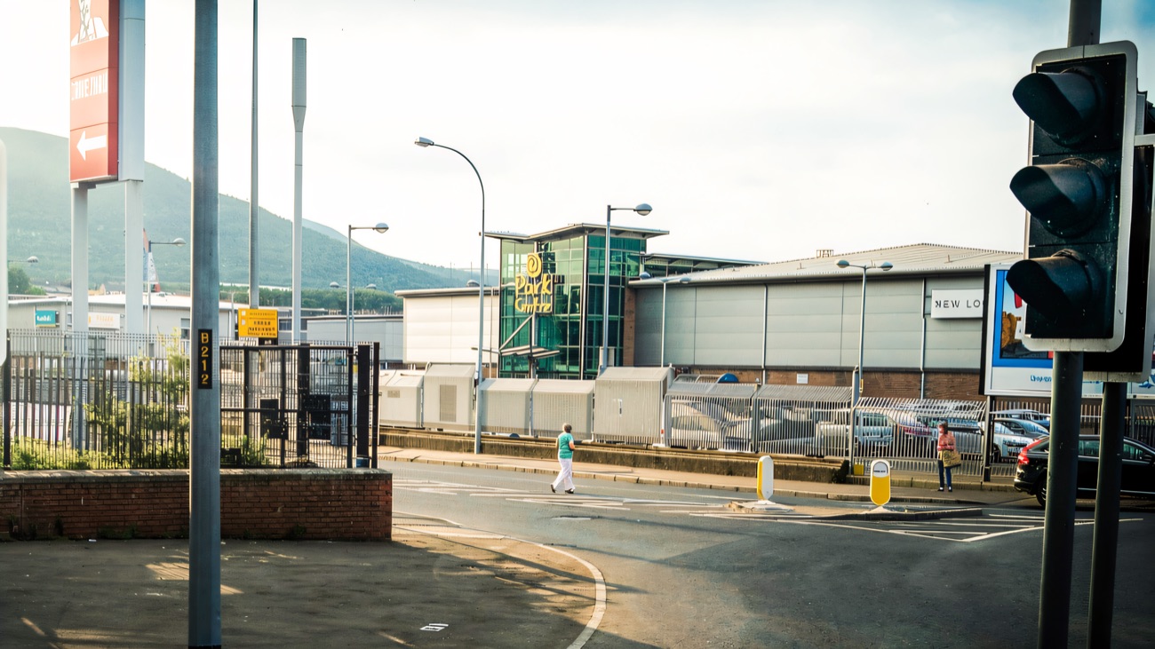 The yellow Park Centre sign on the glass entrance tower on the Donegall Road, with Black Mountain rising behind